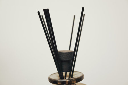 Black and white photo of a candle holder with a black candle inside. The candle holder is made of wood and has a black baseの写真素材