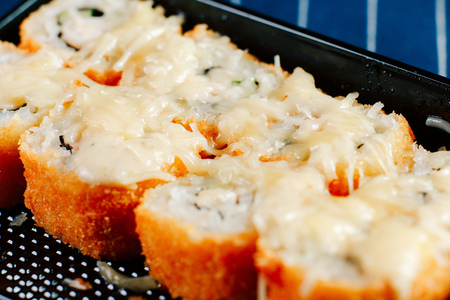 Various kinds of hot fried sushi rolls served on tableの写真素材