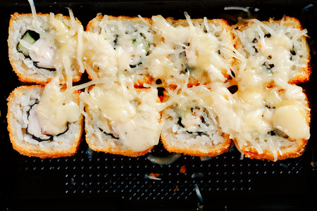 Various kinds of hot fried rolls served in plastic sushi box on tableの写真素材