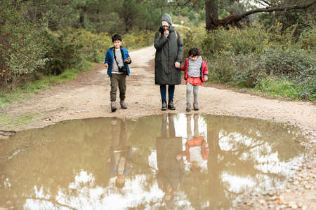 a Caucasian family reflected on water on a road in the bush.の写真素材