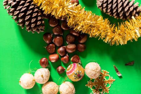 decoration christmas with green background with chestnuts and pine cones. christmas and new year...