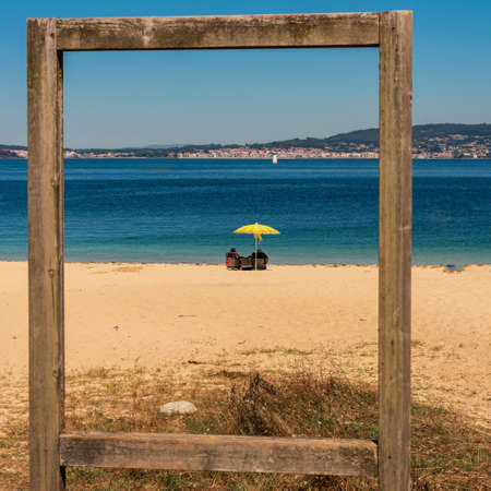 view of the beach through an old wooden structure.の写真素材