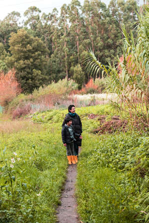 a Caucasian mother and son during a family walk in the forest