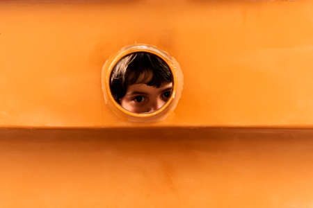 little girl looking through a window of boatの写真素材