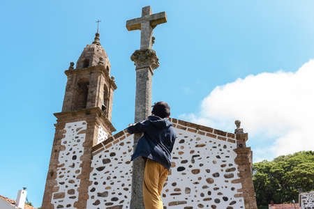boy in front of a church steeple.の写真素材