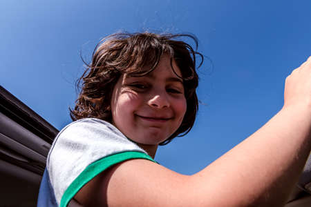 portrait of a girl enjoy while out of the roof of a carの写真素材