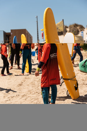 Aveiro, Portugal - August 19, 2022: A group of children practice with a surf instructor on the beach.のeditorial素材