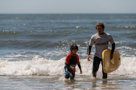 Aveiro, Portugal - August 19, 2022: A group of children practice with a surf instructor on the...