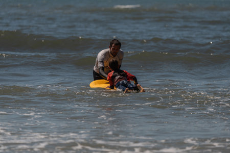 Aveiro, Portugal - August 19, 2022: A group of children practice with a surf instructor on the...