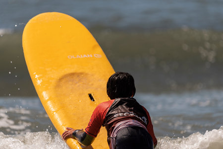 Aveiro, Portugal. august 19 - 2022: Surf lessons for children first class in the beach boy enter...