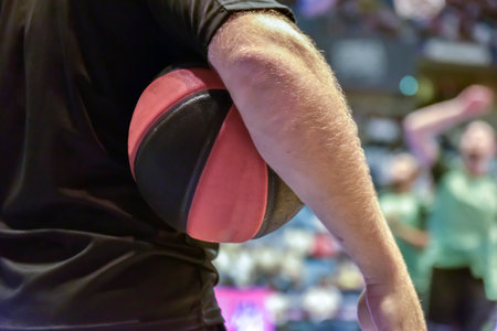 close-up of a basketball held by the referee against his body.の写真素材