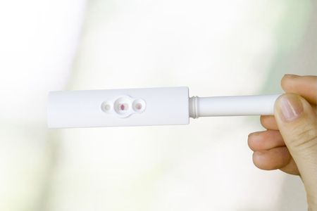 Female hand holding a positive pregnancy test