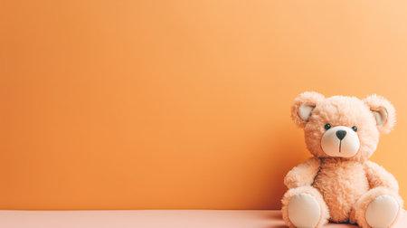 Teddy bear on orange background with copy space, soft focus.の素材