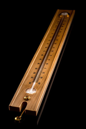 Wooden thermometer on black background. Thermometer on a black background.の素材