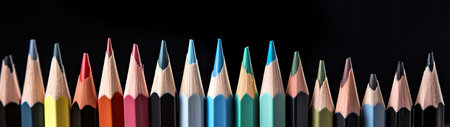 Row of multicolored pencils on black background, panoramic shotの素材