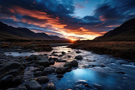 a river running through a valley with rocks and mountains in the backgroundの素材