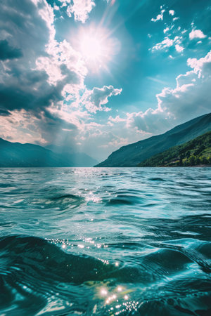 a body of water with mountains and cloudsの素材