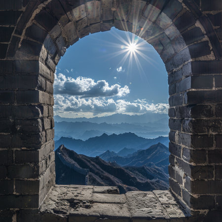 Sunburst over mountain range viewed through ancient stone archwayの素材