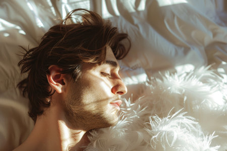 Young man peacefully sleeping in a sunlit bedの素材