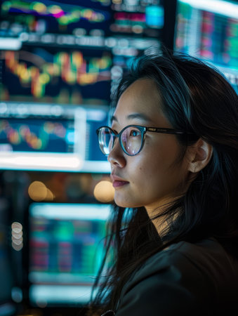 Young woman in glasses looking thoughtful in a bookstoreの素材