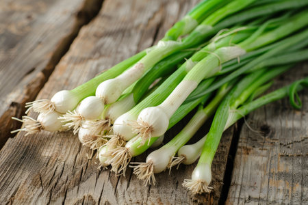 Fresh green onions on a rustic wooden surfaceの素材