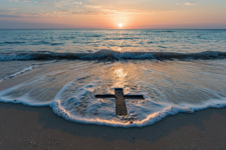 Serene sunset over the ocean with a cross in the sandの素材