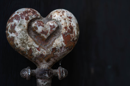 Weathered heart-shaped stone on metal standの素材