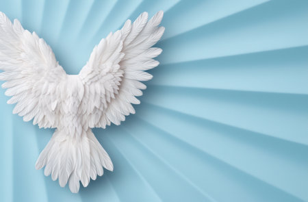 Angelic white feather wings against a blue skyの素材