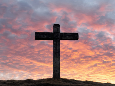 Silhouette of a wooden cross against a dramatic sunset skyの素材