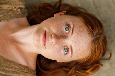 Closeup portrait of a young woman with freckles and vibrant red hairの素材