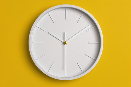 modern minimalist wall clock on yellow backgroundの素材