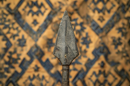 ancient stone spearhead on patterned backgroundの素材