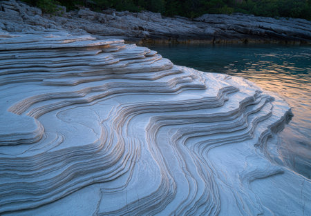 Stunning layered rock formations by the waterの素材