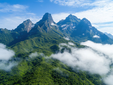 Majestic mountain landscape with lush green forests and cloudsの素材