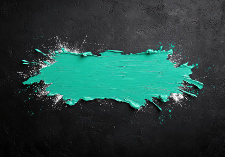 Vibrant teal paint splash on black backgroundの素材