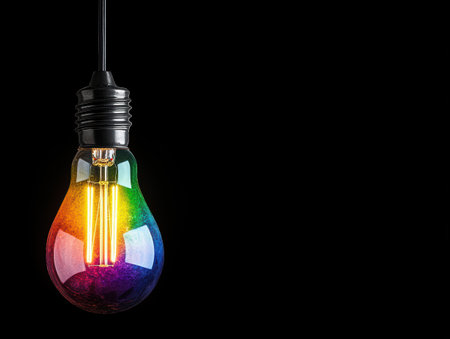 Colorful light bulb against black backgroundの素材
