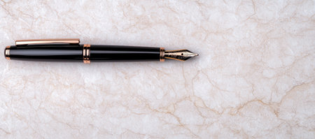 Elegant black and gold fountain pen on marble backgroundの素材