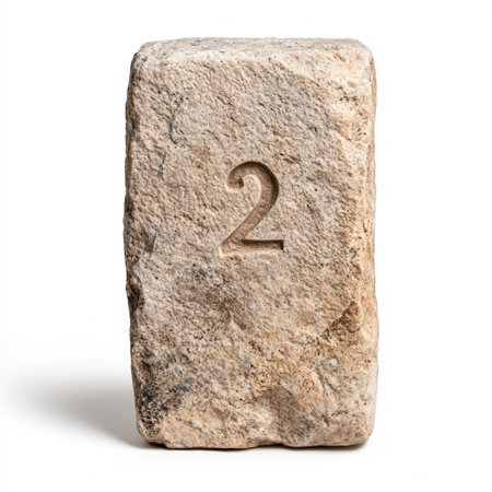 Weathered stone block with carved number twoの素材