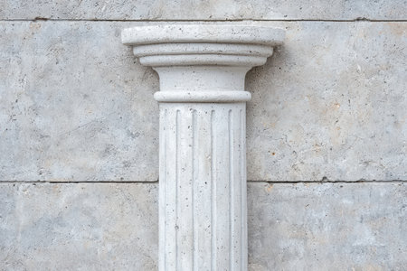 Ornate white concrete column on a textured wallの素材