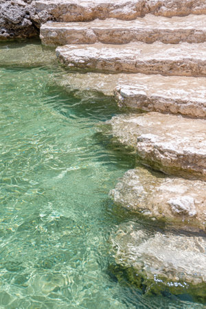 Tranquil turquoise waters flowing over rocky stepsの素材