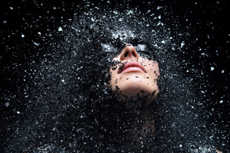 Dramatic close-up of a person's face being splashed with waterの素材