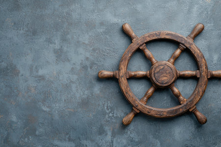 Vintage wooden ship's steering wheel on a textured backgroundの素材
