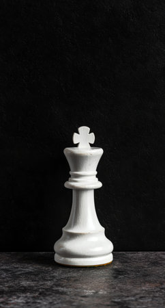 White chess king piece on dark backgroundの素材
