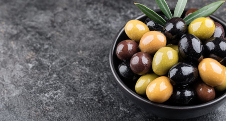 Assorted olives in a black bowlの素材