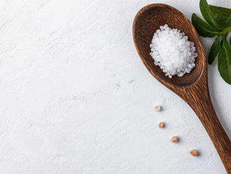 Wooden spoon with sea salt on white backgroundの素材