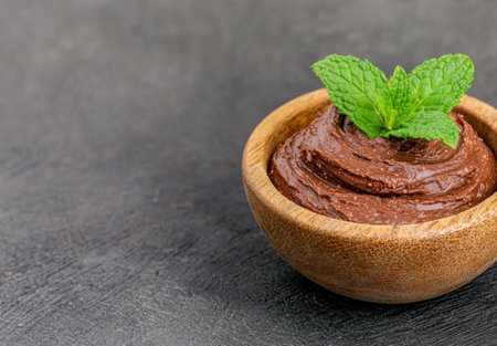 Delicious chocolate mousse dessert in wooden bowl with fresh mint leavesの素材