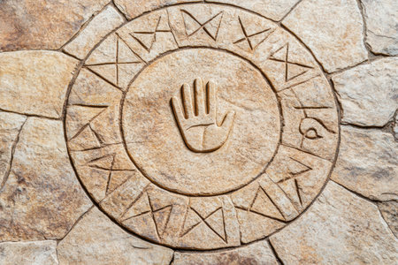 ancient carved stone symbol with hand designの素材