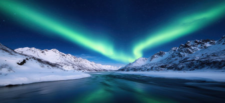Breathtaking northern lights over snowy mountains and frozen lakeの素材