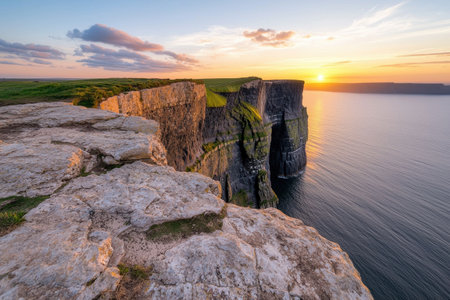 Dramatic sunset over rugged coastal cliffsの素材