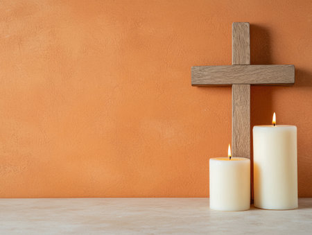 wooden cross and burning candles on orange backgroundの素材